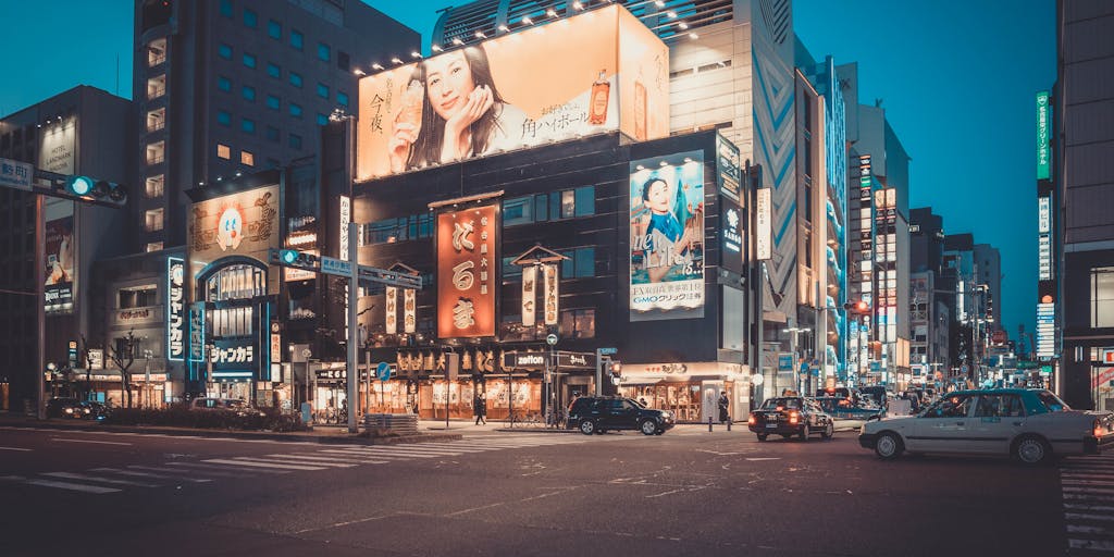 A futuristic cityscape with digital billboards displaying various digital marketing ads. The scene is illuminated at night, showcasing how digital marketing trends are integrated into urban life. The billboards feature eye-catching graphics and QR codes, representing the blend of technology and marketing in everyday environments.