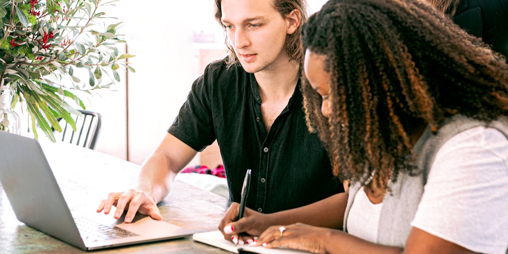 A vibrant and engaging scene of a diverse group of professionals gathered around a large screen displaying a marketing webinar. The participants are actively taking notes and discussing ideas, showcasing collaboration and engagement. The room is filled with modern technology, such as laptops and tablets, emphasizing the digital aspect of marketing.