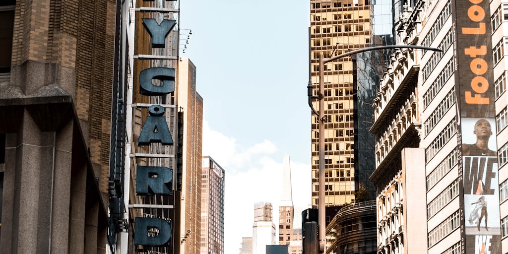 An artistic representation of a digital billboard in a bustling city, showcasing dynamic ads that change based on the viewer's demographics. The photo captures the vibrant energy of the city, with people looking up at the billboard, illustrating the impact of programmatic advertising in real-time.