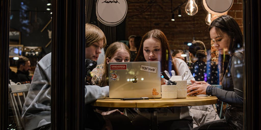 An overhead shot of a diverse group of friends collaborating on a YouTube video, with various props and costumes scattered around. The friends are engaged in a lively discussion, brainstorming ideas, and laughing together, emphasizing the importance of collaboration and community in gaining fame on the platform.