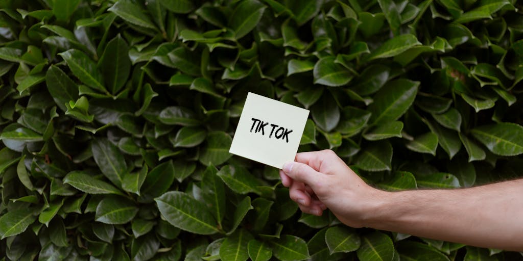 A split image showing two contrasting scenes: on one side, a person happily engaging with TikTok content on their phone, and on the other side, a frustrated marketer surrounded by bills and advertising invoices. This juxtaposition visually represents the excitement of TikTok as a platform versus the reality of advertising costs.