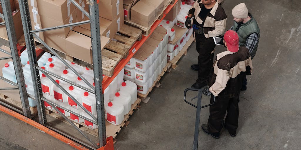 A behind-the-scenes shot of a JD.com warehouse, featuring employees efficiently picking and packing orders. The photo should convey a sense of teamwork and speed, with workers in branded uniforms and high-tech equipment. Use wide-angle photography to capture the scale of the operation, emphasizing the company's commitment to fast delivery.