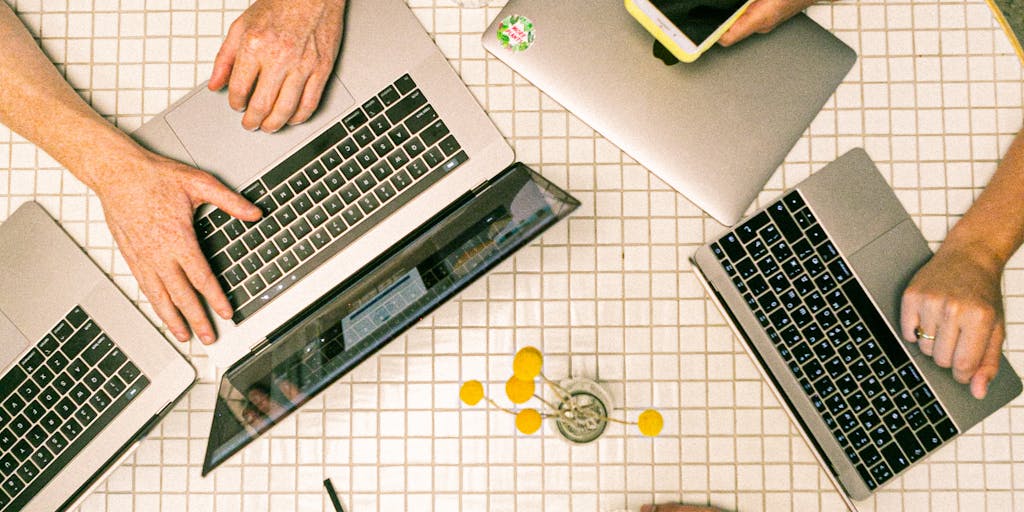 An overhead shot of a diverse group of people brainstorming around a table filled with digital devices, charts, and graphs. The image should capture the collaborative spirit of developing a Shopify marketing strategy, with a focus on inclusivity and teamwork.