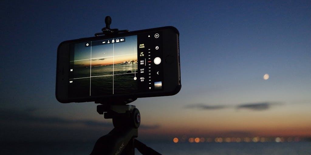 A close-up shot of a person holding a smartphone displaying a wish list app, with a dreamy background of clouds and stars. The image conveys the idea of digital wish marketing, where consumers can express their desires and brands can cater to those wishes.