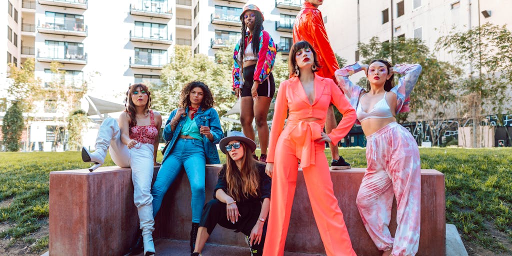 A dynamic street style photo featuring a diverse group of fashion influencers wearing unique outfits purchased from Farfetch. Capture them in an urban setting, engaging with each other and showcasing their individual styles. This image should highlight the community aspect of Farfetch's marketing strategy and its appeal to trendsetters.