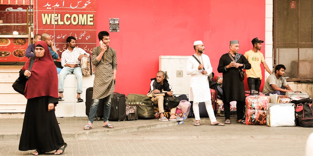 A vibrant marketplace scene showcasing a diverse group of people engaging in group buying on their smartphones. The background features colorful banners and advertisements promoting Pinduoduo's unique marketing strategies, such as team purchases and discounts. The atmosphere is lively, with people smiling and interacting, emphasizing community and collaboration.