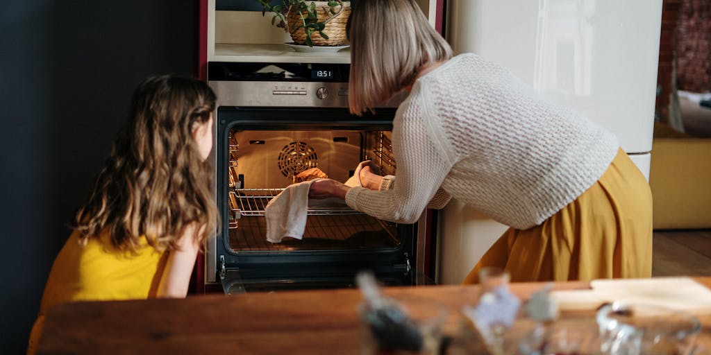 An engaging image of a family gathered around a kitchen island, preparing a meal using ingredients sourced from Ocado. The family should be laughing and enjoying the cooking process, showcasing the joy of cooking with quality ingredients. This emphasizes the lifestyle aspect of Ocado's marketing strategy.