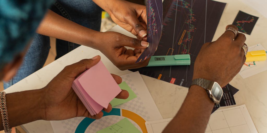 An overhead shot of a brainstorming session with sticky notes and sketches related to Redbubble marketing strategies spread out on a table. Include coffee cups and digital devices to convey a collaborative and dynamic environment.