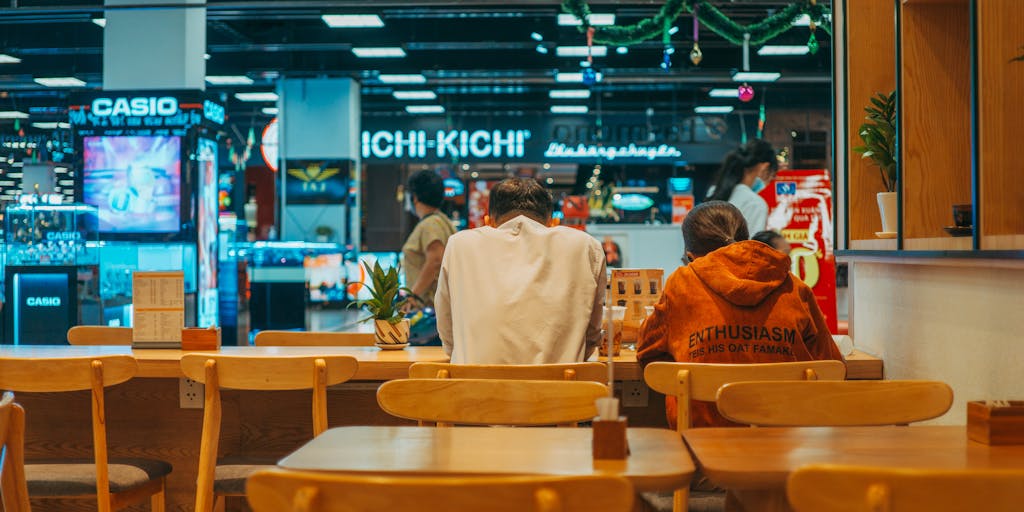 A vibrant, bustling restaurant scene showcasing a diverse group of diners enjoying their meals. The focus is on a table with an OpenTable reservation confirmation on a smartphone, highlighting the convenience of online reservations. The ambiance should reflect a warm, inviting atmosphere with soft lighting and colorful decor.