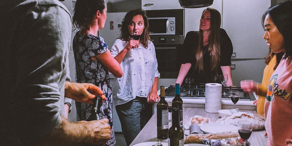 A vibrant kitchen scene featuring a diverse group of friends cooking together using HelloFresh meal kits. The table is filled with colorful ingredients and recipe cards, showcasing the joy of cooking and sharing meals. The atmosphere is lively, with laughter and conversation, emphasizing the community aspect of HelloFresh.