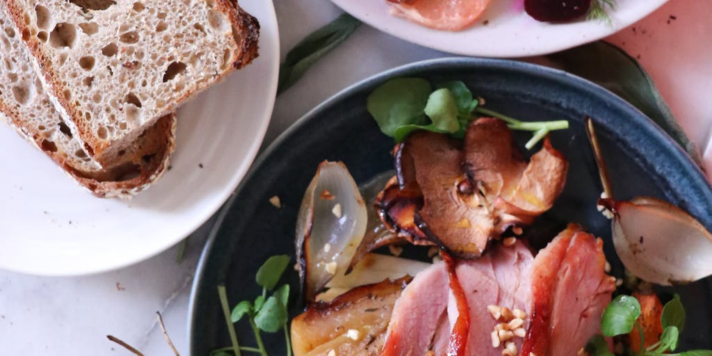 An overhead shot of a beautifully arranged HelloFresh meal on a dining table, with the meal kit box partially open beside it. The photo captures the freshness of the ingredients and the final plated dish, highlighting the ease and convenience of preparing a gourmet meal at home.