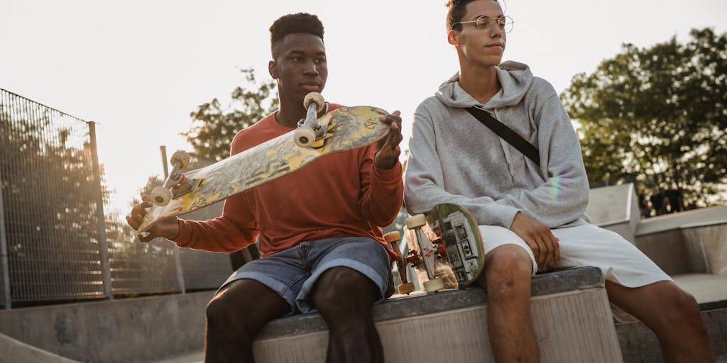 A vibrant, urban scene featuring a diverse group of friends wearing stylish Warby Parker glasses while enjoying a sunny day at a local park. The background includes colorful murals and street art, symbolizing creativity and community engagement, which aligns with Warby Parker's brand ethos.