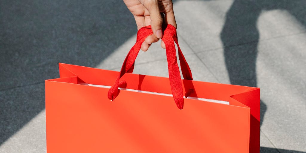 A dynamic photo of a Warby Parker pop-up shop at a trendy event, showcasing people interacting with the brand. The scene should include engaging displays, customers trying on glasses, and a lively atmosphere, highlighting Warby Parker's innovative marketing strategies and community involvement.