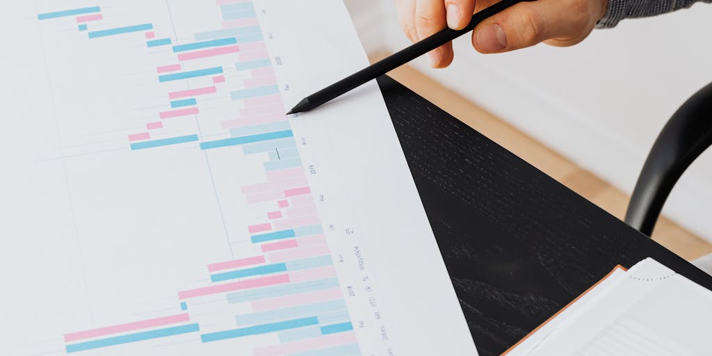 An overhead shot of a laptop displaying Salesforce analytics dashboards, surrounded by marketing materials like brochures, business cards, and a cup of coffee. This composition highlights the integration of technology and traditional marketing tools in a cohesive strategy.