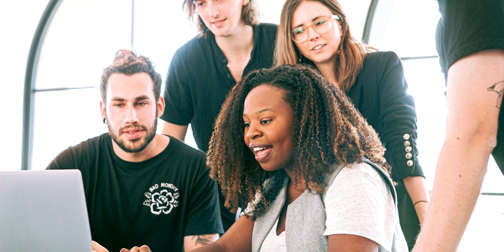 A vibrant workspace featuring a diverse team of marketers collaborating over a large digital screen displaying Adobe Marketing tools and analytics. The atmosphere is dynamic, with sticky notes and brainstorming materials scattered around, showcasing creativity and teamwork.