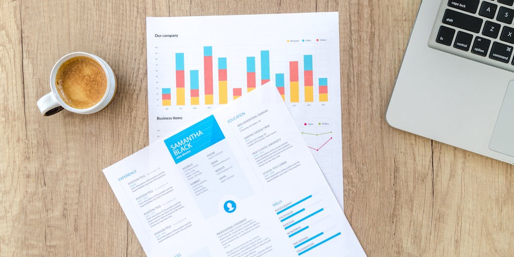 An overhead shot of a laptop displaying Coupa Software's marketing analytics dashboard, surrounded by coffee cups, notepads, and digital devices. This image captures the essence of data-driven decision-making in marketing strategy, emphasizing the importance of analytics in Coupa's approach.