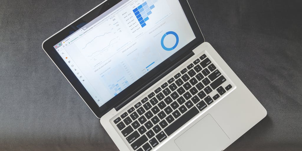 An overhead shot of a laptop displaying Freshworks' marketing analytics dashboard, surrounded by coffee cups, notepads, and digital devices. This image captures the essence of data-driven decision-making in marketing strategy.