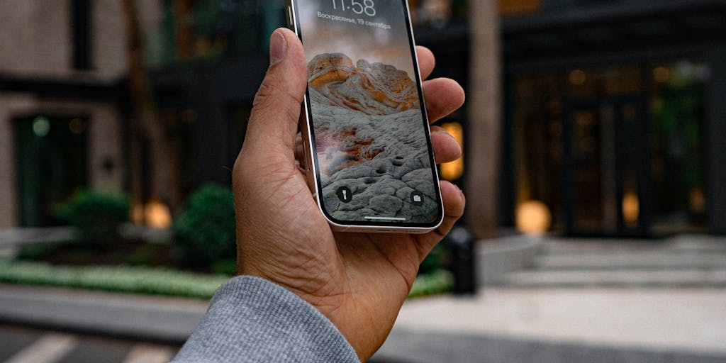 A close-up of a hand holding a smartphone displaying the Airtable app, with a blurred background of a city skyline. The image symbolizes the accessibility and flexibility of managing marketing strategies on-the-go, emphasizing modern digital marketing practices.