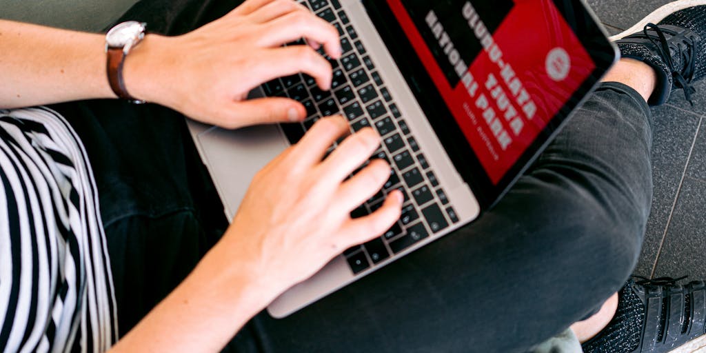 A vibrant workspace featuring a laptop open to a Canva design interface, surrounded by colorful marketing materials like flyers, business cards, and social media posts. The scene should include a cup of coffee and a notepad with brainstorming notes, conveying a creative and productive atmosphere.