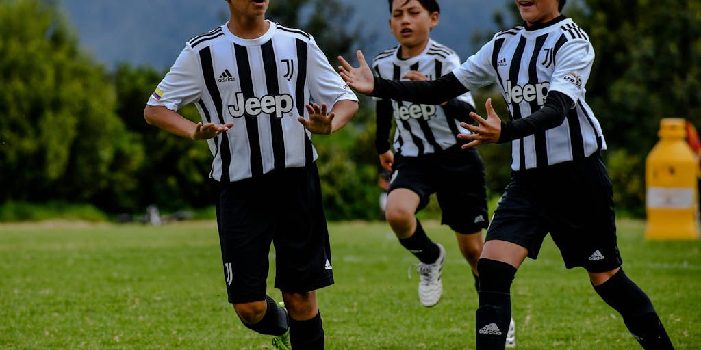 An overhead view of a Juventus-themed pop-up store during a match day, bustling with fans trying on jerseys and purchasing merchandise. The store is decorated with large banners and digital screens displaying promotional content. This photo highlights the club's innovative retail strategies and fan engagement efforts, emphasizing the experience of shopping on match days.