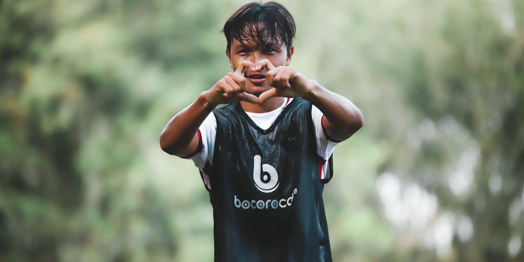 A close-up shot of a young athlete wearing a Sporting CP jersey while practicing soccer skills in a local park. The image should convey the message of youth engagement and the club's commitment to nurturing future talent, reflecting the marketing strategy focused on grassroots initiatives.