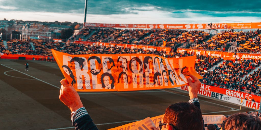 A dynamic action shot of a Shakhtar Donetsk player celebrating a goal, with a blurred background of ecstatic fans in the stands. The image captures the emotion and excitement of a match day, emphasizing the connection between the team and its supporters.