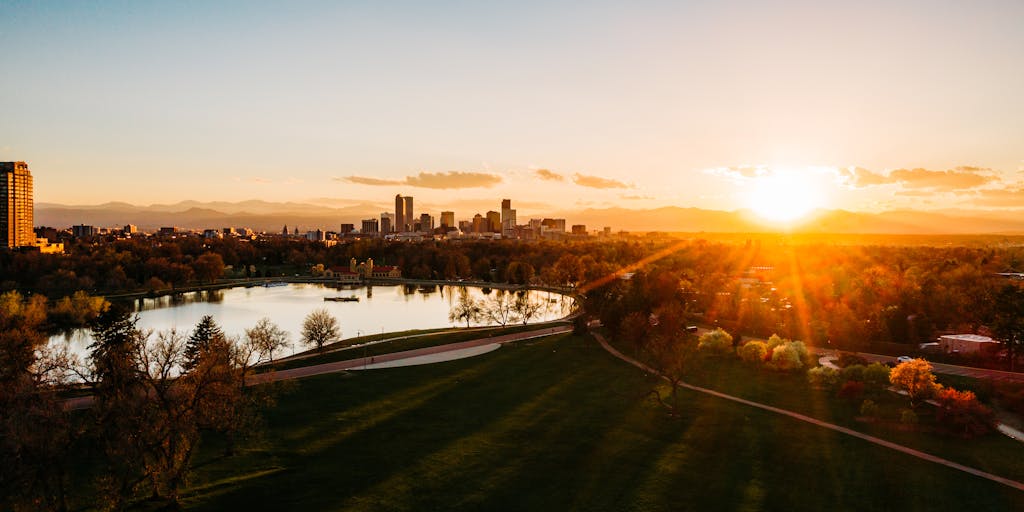 An aerial shot of the Denver skyline with the iconic Rocky Mountains in the background, overlaid with the Denver Broncos logo and a motivational slogan like 'Unleash the Bronco Spirit'. This image highlights the team's connection to the city and its stunning natural surroundings.