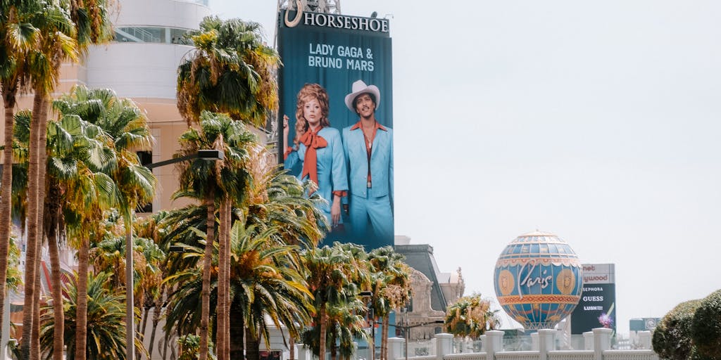 A creative concept photo featuring a digital billboard in Las Vegas showcasing the Raiders' latest marketing campaign. The billboard displays eye-catching graphics and slogans, with a bustling Las Vegas street scene in the foreground. This image captures the intersection of sports marketing and the vibrant city life of Las Vegas, emphasizing the team's presence in the community.