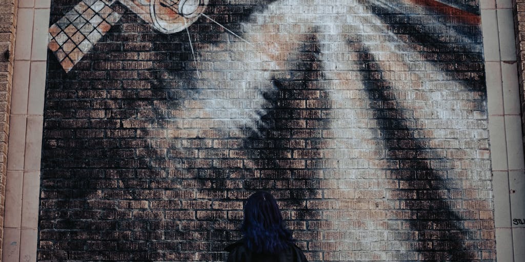 A creative shot of a local artist painting a mural of Saints players on a brick wall, with fans admiring the artwork. This image emphasizes the collaboration between the team and local artists, showcasing how the Saints are integrated into the community and culture of New Orleans.