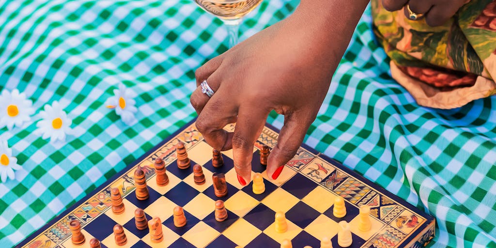 A creative flat lay of a game day setup featuring a Jets-themed picnic. The arrangement includes Jets-branded snacks, drinks, and merchandise, all laid out on a green and white checkered blanket. This photo idea promotes the idea of community gatherings and tailgating culture associated with the Jets.