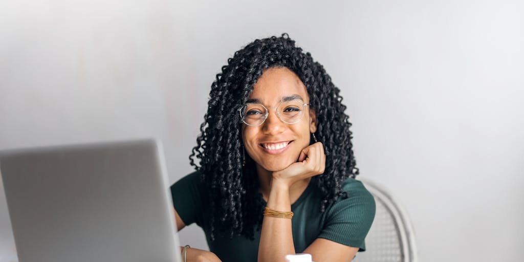 A dynamic action shot of a person giving a thumbs up while looking at their screen, which displays a successful result from using Instantly.ai. The background should be slightly blurred to focus on the person's expression and the screen, conveying excitement and approval.