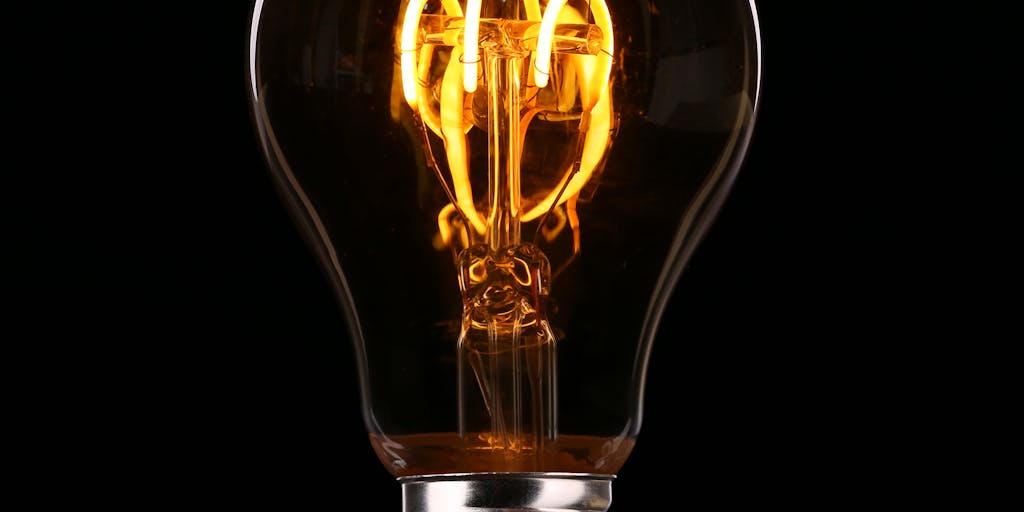 A conceptual image of a light bulb above a laptop, symbolizing innovation and ideas generated through Instantly.ai. The light bulb should be glowing, and the laptop screen should show graphs or analytics, representing the insights gained from the platform.