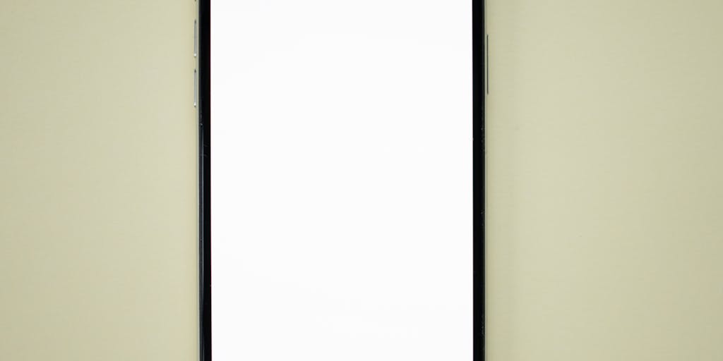 A close-up shot of a smartphone displaying the Dripify app interface, with colorful drip effects artistically overlaying the screen. The background features a blurred workspace with a laptop and coffee cup, symbolizing productivity and digital marketing.