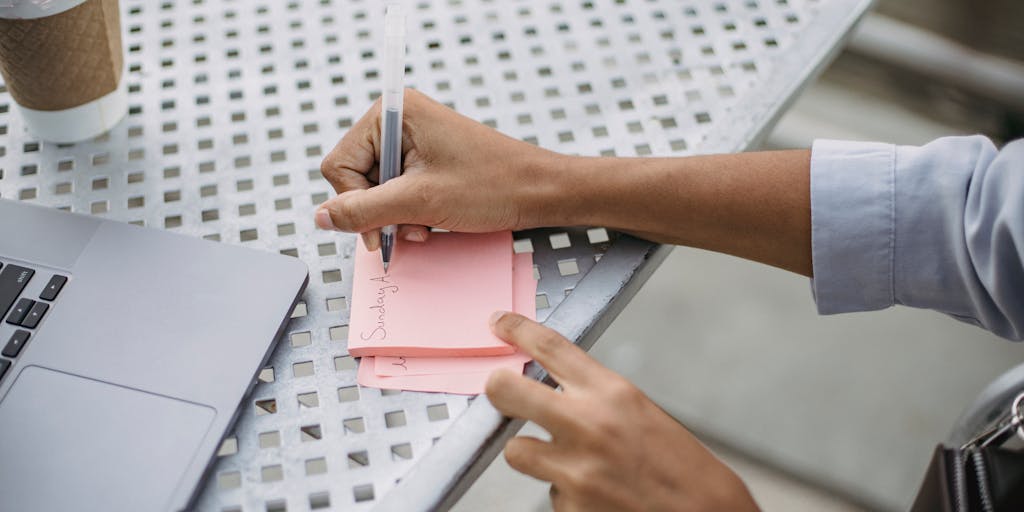 An overhead view of a workspace with a laptop open to the Audienceful Review website, surrounded by colorful sticky notes and coffee cups. The scene conveys a sense of collaboration and brainstorming, with a focus on creativity and productivity.
