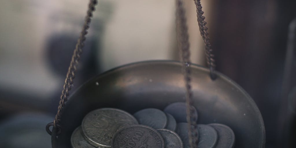 An artistic representation of a scale balancing a rocket and a stack of coins, symbolizing the balance between investment and potential return. The background could be a starry night sky, emphasizing the limitless possibilities with Rocketreach.