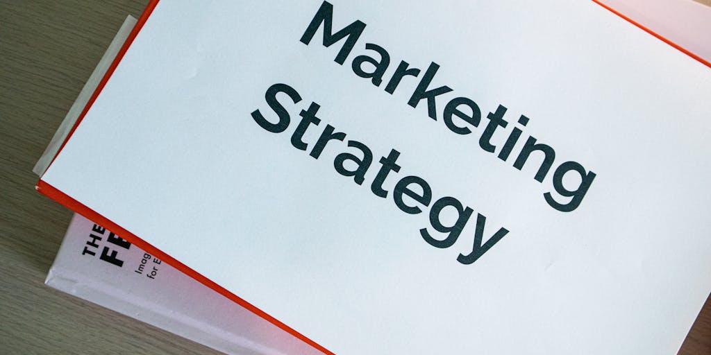 An overhead view of a desk cluttered with various marketing materials, including brochures and charts that highlight Outreach IO pricing. A laptop is open with a graph showing growth, symbolizing the impact of pricing on business success.