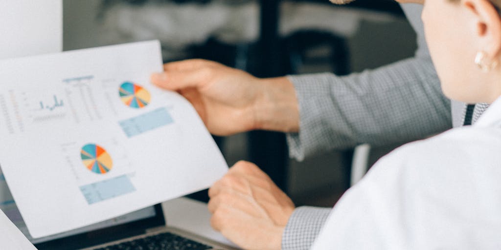 A dynamic image of a diverse team in a meeting room, discussing Sales Loft pricing strategies. The team is engaged, with charts and graphs projected on a screen behind them, showcasing data-driven decision-making.