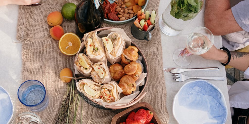 An overhead shot of a dining table set for a meal, with price tags creatively placed next to each dish. The table is beautifully arranged with vibrant dishes, and the price tags are designed in a playful, eye-catching style that reflects the Yamm brand.