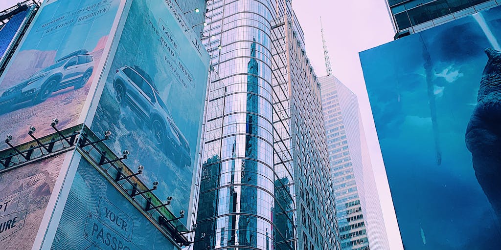 A futuristic city skyline at dusk, with digital billboards showcasing real-time pricing updates for various products and services. This image represents the integration of Bardeen Pricing into everyday life and commerce.