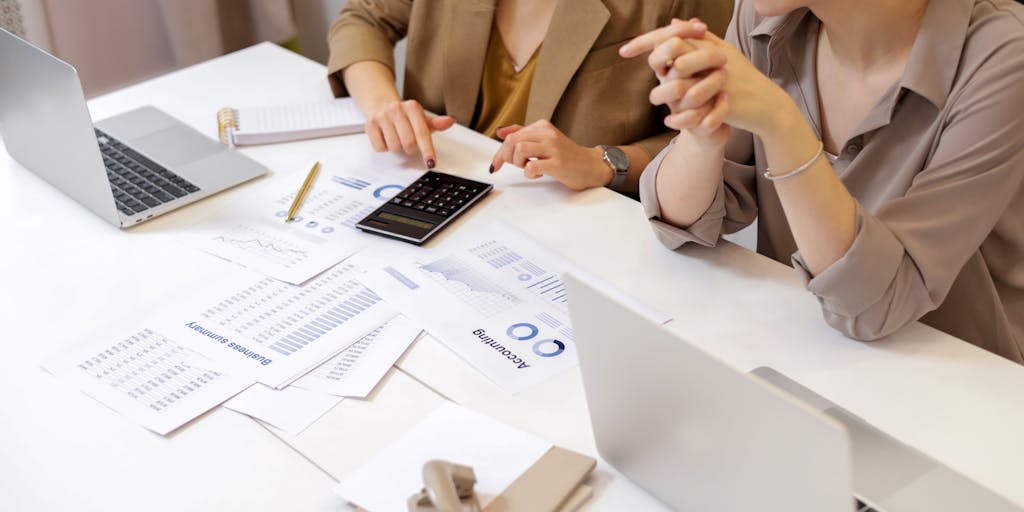 A close-up shot of a calculator with a hand typing in numbers, surrounded by charts and graphs that represent pricing strategies. The background should be blurred to emphasize the calculator and the financial documents, symbolizing the analytical aspect of Lead411 pricing.