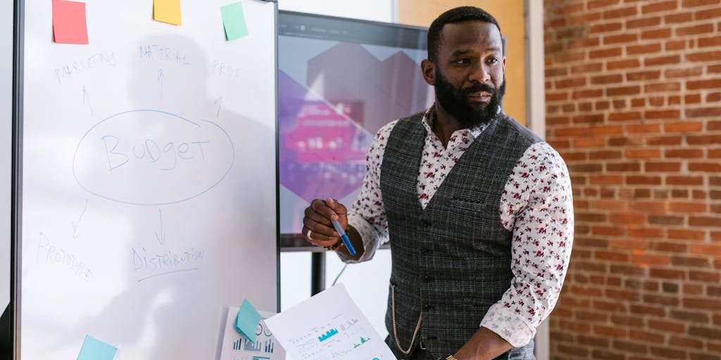 An overhead view of a creative workspace with a whiteboard filled with pricing strategies and sales engagement ideas. Include sticky notes, colorful markers, and a laptop open to a sales dashboard, showcasing a collaborative environment.
