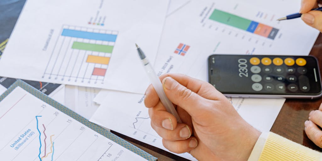 A close-up shot of a calculator with a hand pressing buttons, surrounded by colorful charts and graphs that represent pricing strategies. The background should be slightly blurred to emphasize the calculator and the financial data, symbolizing the analytical aspect of pricing.