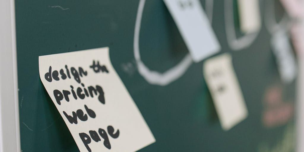 A close-up shot of a sales team brainstorming around a table filled with charts, graphs, and pricing models. The focus is on a whiteboard with colorful sticky notes outlining different pricing strategies, showcasing collaboration and creativity in sales enablement.