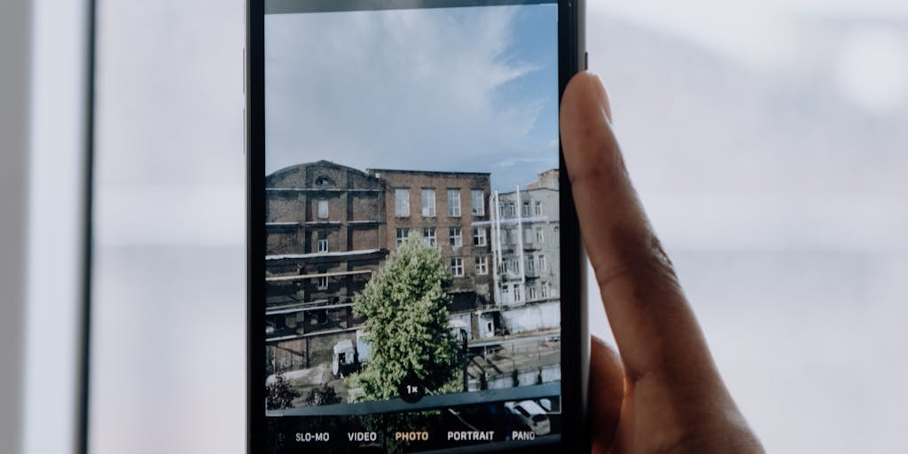 A close-up shot of a hand holding a smartphone displaying the Rei Reply Pricing interface, with a blurred background of a cozy outdoor setting, such as a campsite or a park. The focus on the phone highlights the pricing details while the natural setting conveys a sense of adventure and exploration.