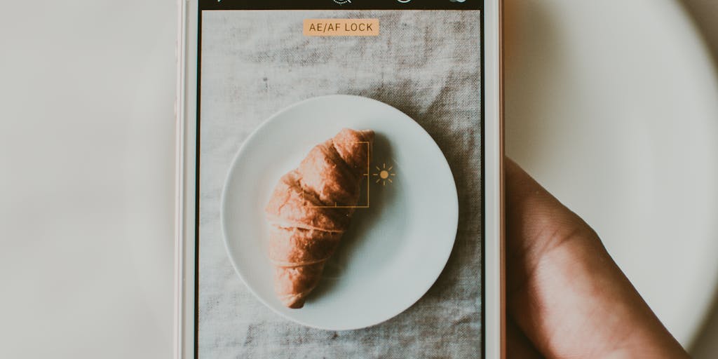 A close-up shot of a person holding a smartphone displaying the Arvow Review app interface, with a blurred background of a cozy café setting. The focus is on the app, showcasing its user-friendly design and vibrant colors, while the warm ambiance of the café adds a personal touch.