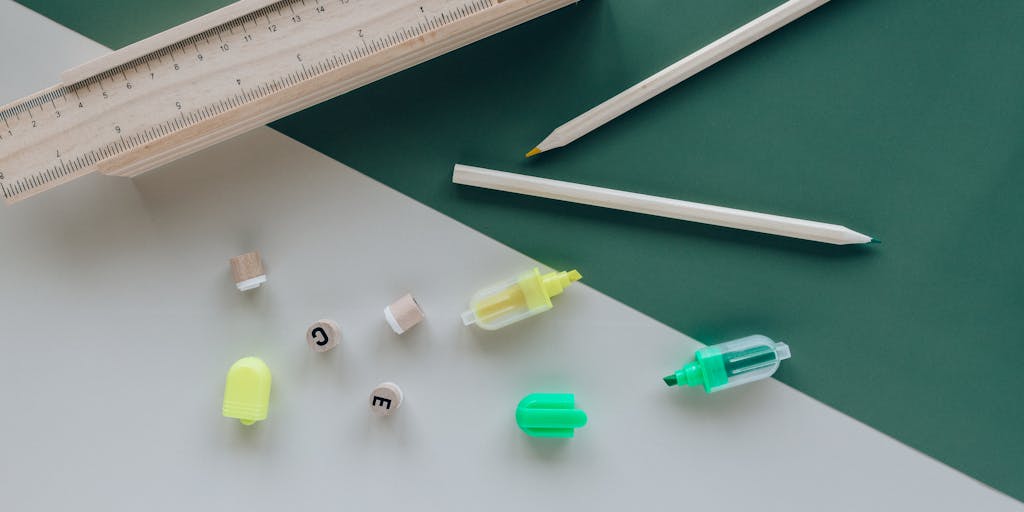 An artistic flat lay of various writing tools, including a notebook, pens, and a tablet showing the Zimmwriter logo. The background is a textured wooden table, and there are scattered pages with handwritten notes to emphasize the writing process.