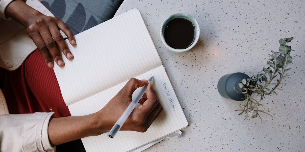An overhead view of a desk cluttered with notebooks, pens, and a smartphone displaying the Shortly AI app. The scene is vibrant, with colorful stationery and a plant in the corner, creating a creative workspace atmosphere.