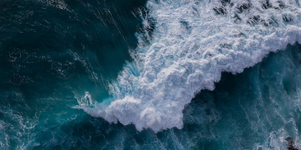 An aerial shot of a surfer catching a wave, with a digital overlay of SEO keywords and analytics floating above the water. The contrast between the natural beauty of the ocean and the digital elements emphasizes the concept of merging surfing with SEO strategies.