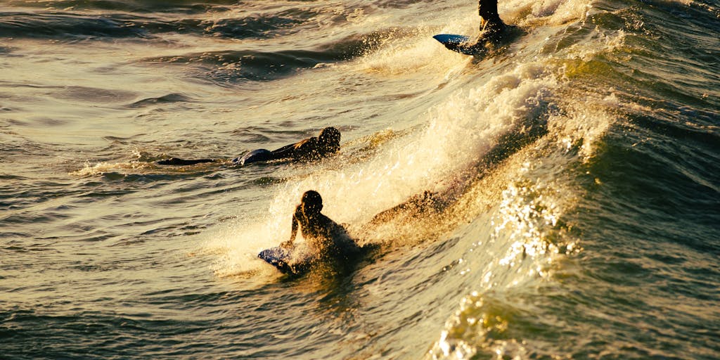 A vibrant beach scene at sunset, featuring a group of diverse surfers discussing strategies while sitting on their surfboards. The warm colors of the sunset reflect on the water, creating a serene yet dynamic atmosphere that symbolizes collaboration and innovation in surfing.