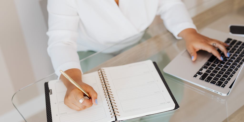 A split-screen image showing a person using a laptop on one side, with a vibrant, colorful interface of a writing tool on the screen. On the other side, the same person is surrounded by traditional writing tools like notebooks, pens, and sticky notes, symbolizing the contrast between digital and analog writing methods.